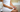 Woman in towel holding a pregnancy test while waiting during the implantation window — early pregnancy symptom awareness and two-week wait concept.