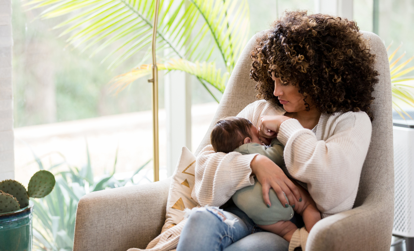 postpartum mom holding baby while sitting in chair | nursing and bonding | awaitingthestork.com