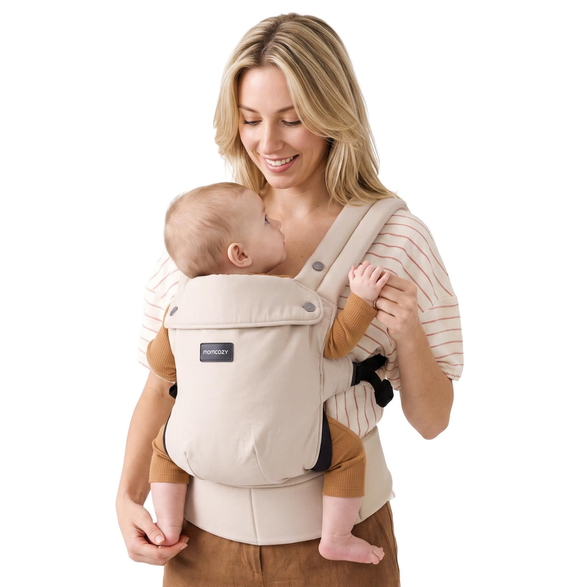 Mother wearing the Momcozy PureHug baby carrier in khaki with her baby facing in