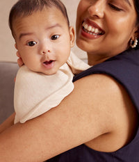 Baby in the oatmeal Swaddle Up showing the snug shoulder fit
