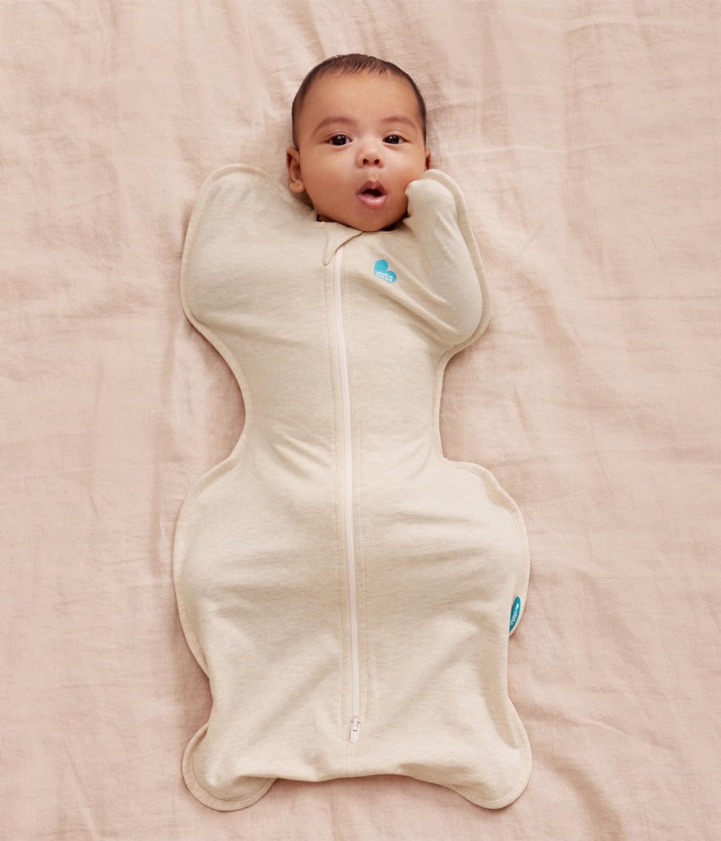 Newborn resting arms-up in the oatmeal Swaddle Up swaddle