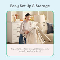 Woman folding the Newton Compact travel crib for storage