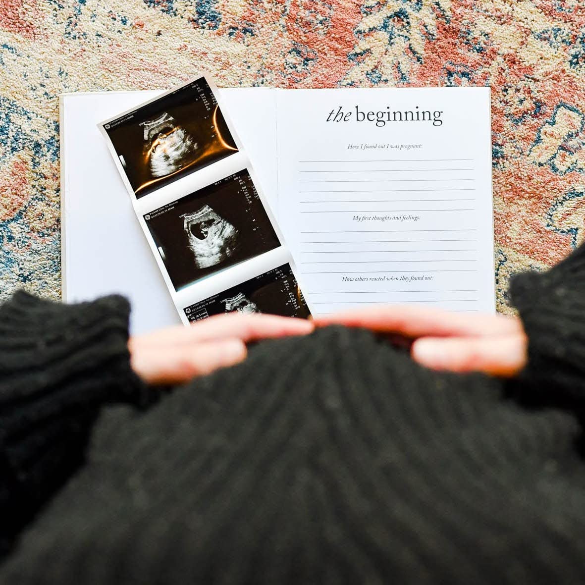 Expecting mother holding a pregnancy journal with ultrasound images, reflecting on her journey in a pregnancy journal.