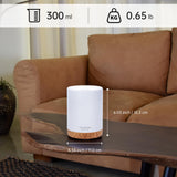 Essential oil diffuser on a wooden table, enhancing relaxation in a cozy living room setting.