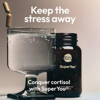 Stress relief supplements for women by Moon Juice SuperYou in a glass with water.