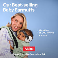 Baby in a carrier wearing Alpine Muffy Baby earmuffs with a black and white striped headband, held close by a parent