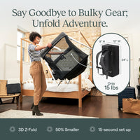 Woman unfolding the Guava Lotus travel crib, with the 15 lb backpack it packs into