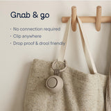 Portable sound machine for baby clipped on a bag for easy access and travel convenience.