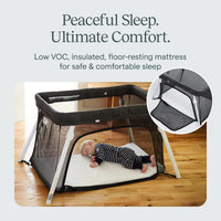 Baby asleep on the bare floor-resting mattress of the Guava Lotus travel crib