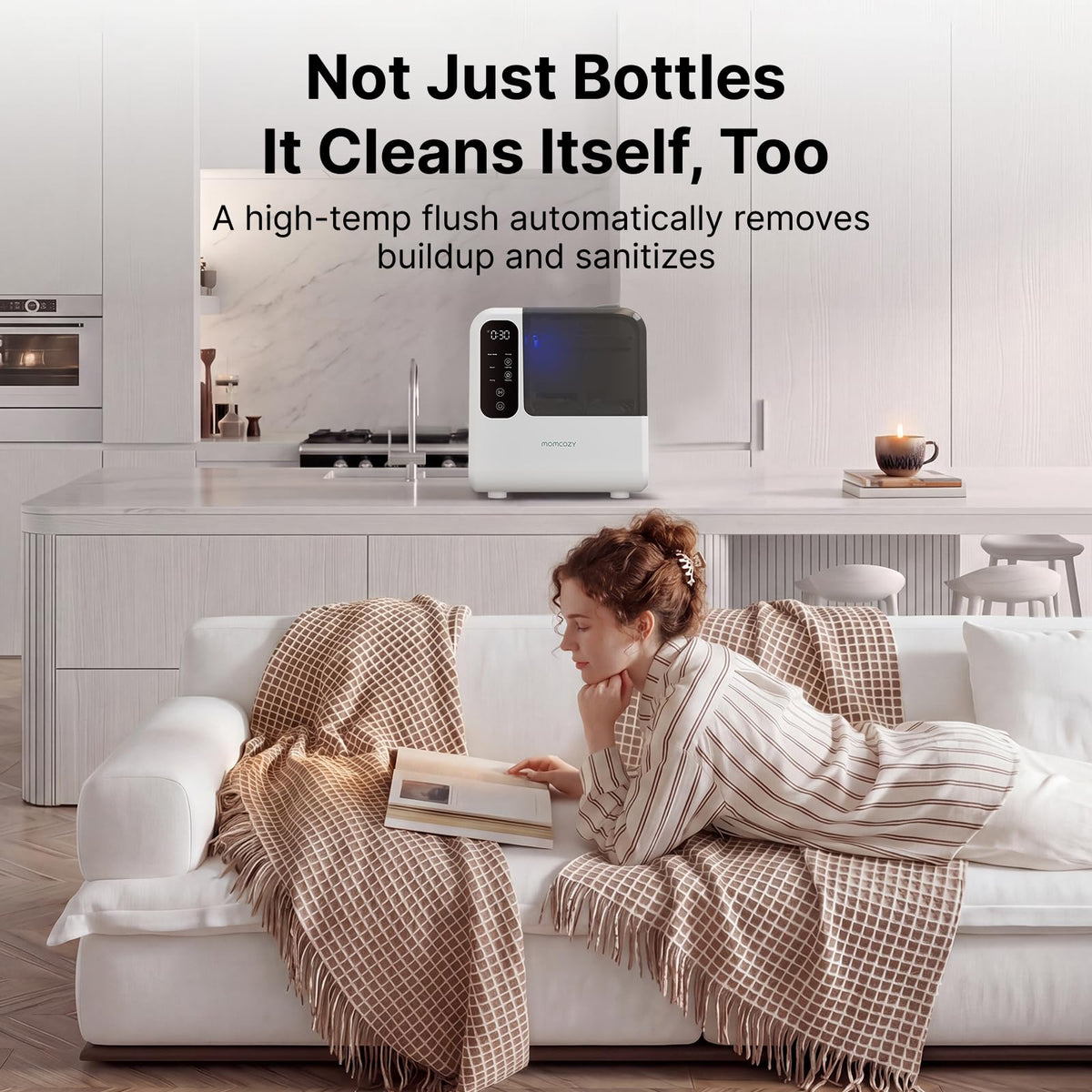 Momcozy D8 bottle washer on a kitchen counter beside the sink, advertising its self-clean mode