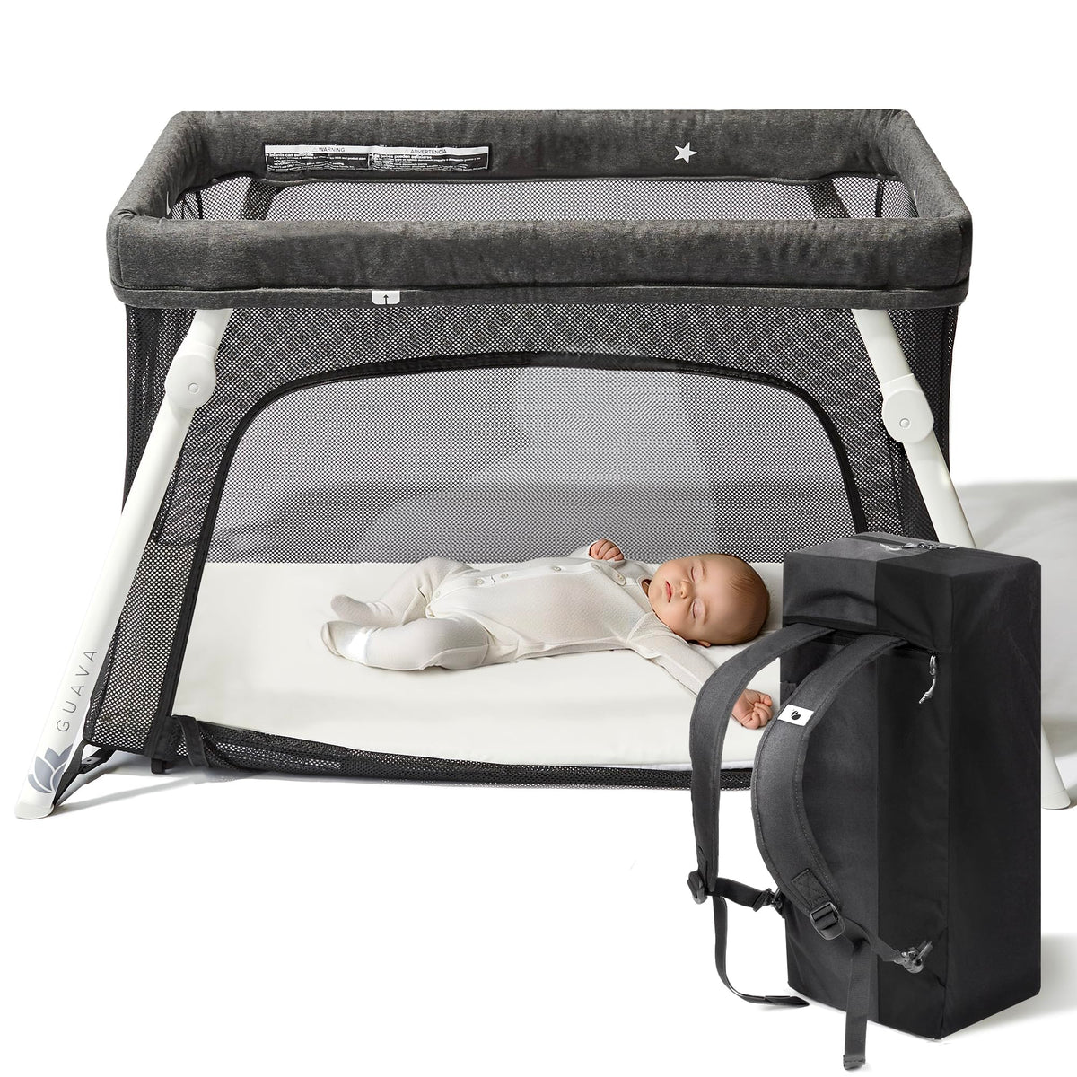 Guava Lotus travel crib set up with a baby on the floor-level mattress, next to its backpack carry bag