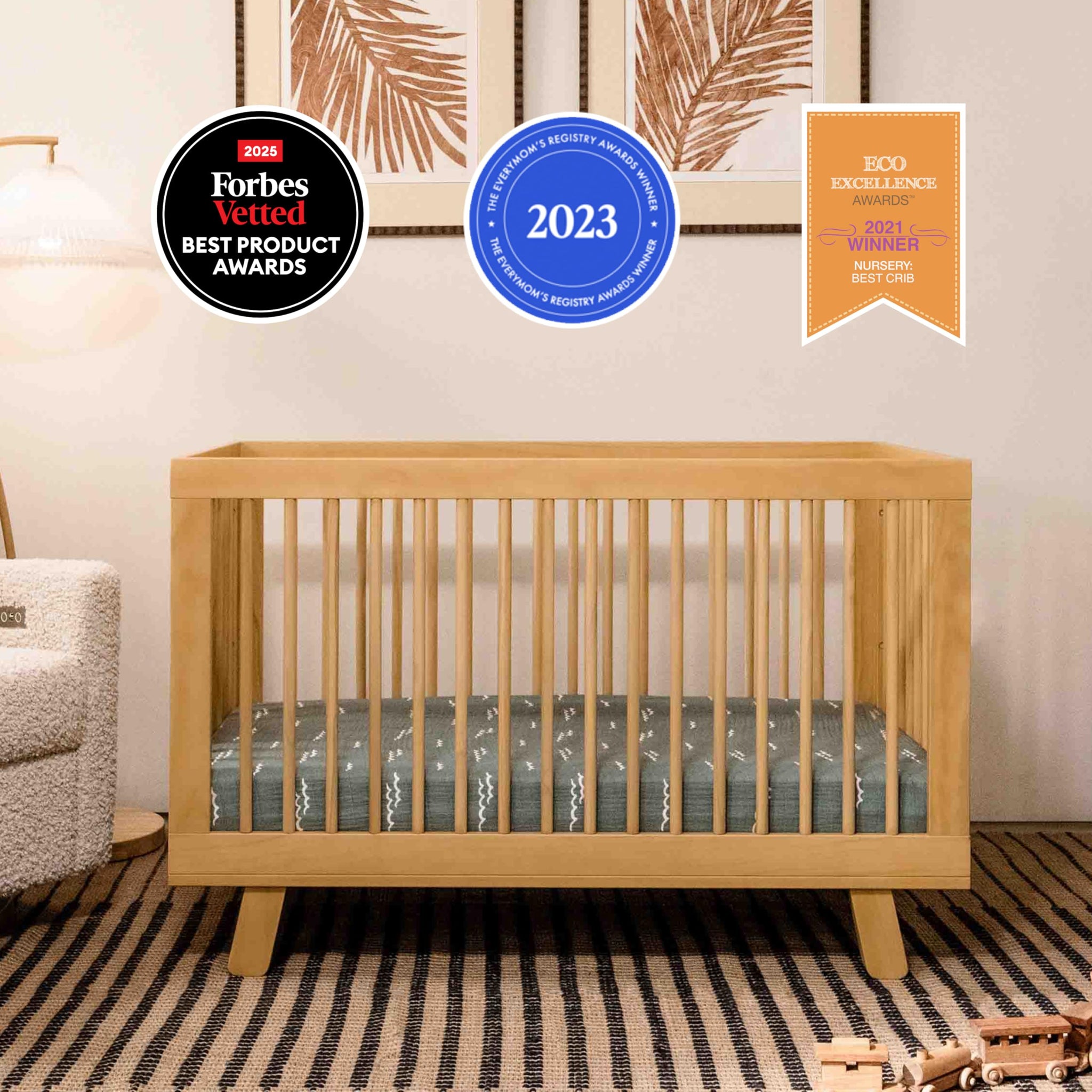 Babyletto Hudson 3-in-1 Convertible Crib in warm wood finish, shown in modern nursery setting with awards.